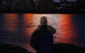 FILE - In this photo made with a long exposure, a man is silhouetted against lights reflected in the waters off Cape Neddick in Maine on Dec. 11, 2017. Federal health advisers are considering the first request to approve the mind-altering club drug MDMA as a treatment for PTSD. The advisers to the Food and Drug Administration are scheduled to vote on the drug's safety and effectiveness Tuesday, June 4, 2024, potentially setting the stage for federal approval later this year. (AP Photo/Robert F. Bukaty, File)