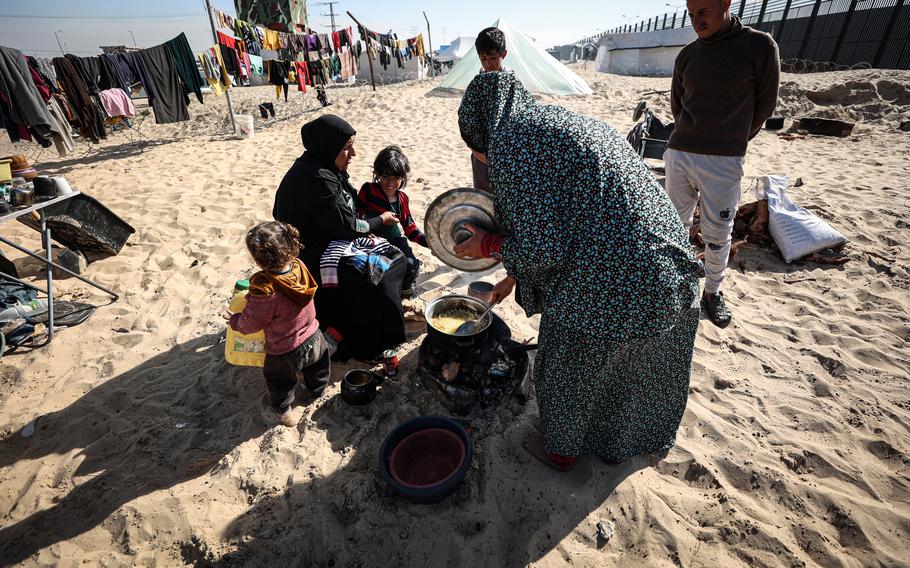 Shahinaz Nofal’s family cooks lunch inside a camp housing displaced people on the Egypt-Gaza border, south of Rafah, on Jan. 21, 2024.