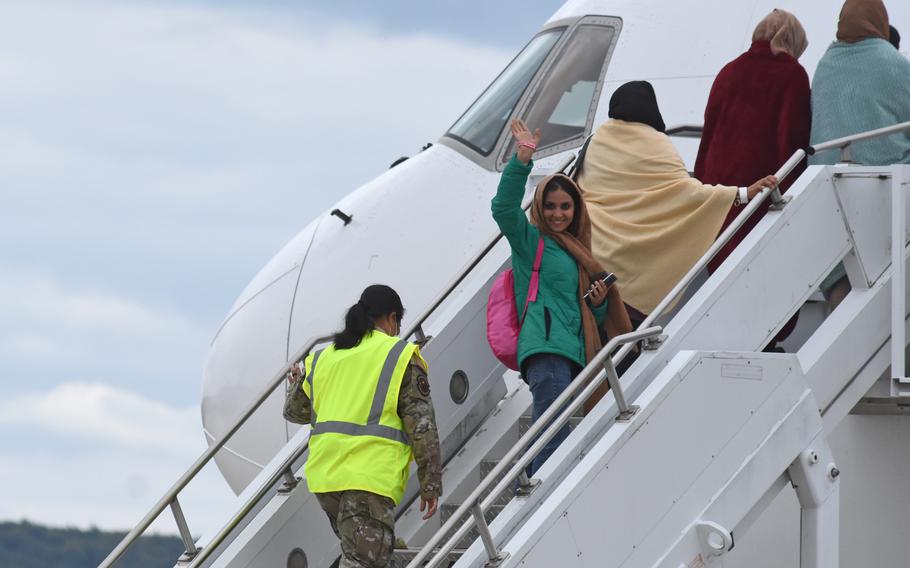 An Afghan evacuee boards a commercial flight at Ramstein Air Base, Germany, on Aug. 26, 2021. Flights carrying Afghans to the U.S. are still on hold three days after it was announced that flights would be halted because of measles infections among evacuees who recently arrived in the United States.
