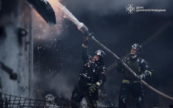 Firefighters put out a fire following a Russian missile attack.