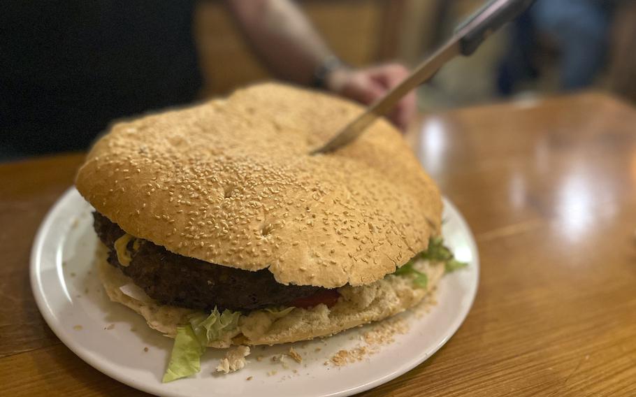The XXXXXL Burger, which is about a foot wide, is served with a large bread knife at XXL Restaurant Waldgeist Hofheim, Germany, on March 18, 2024.