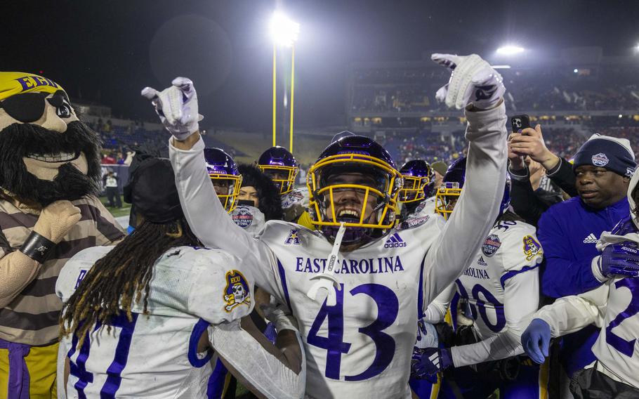 A football player cheers on a football field.