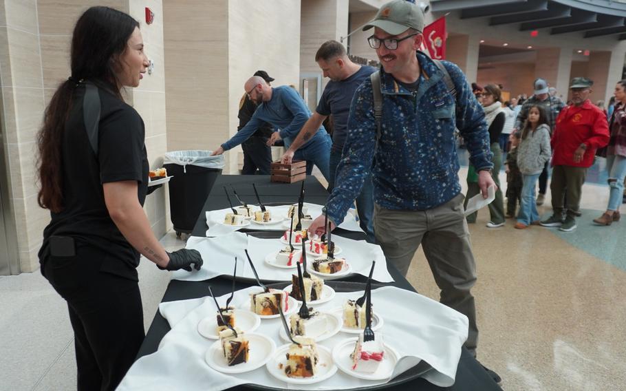 A guest takes a piece of birthday cake