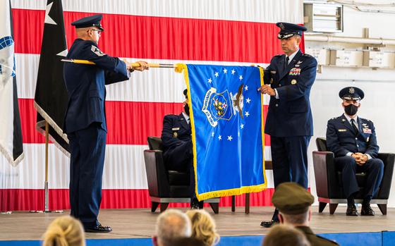 Two men handle a flag as part of a ceremony at Peterson Air Force Base, Colo. to establish Space Operations Command, Oct. 21, 2020.