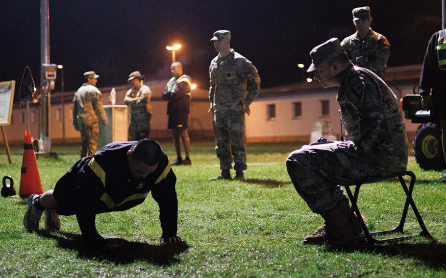 A soldier is shown holding a plank on a grassy area.