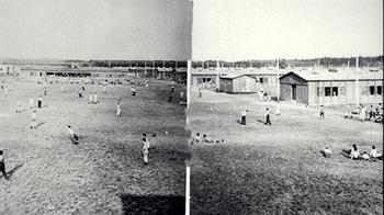 A black and white view of the camp, with prisoners scattered across the yard.