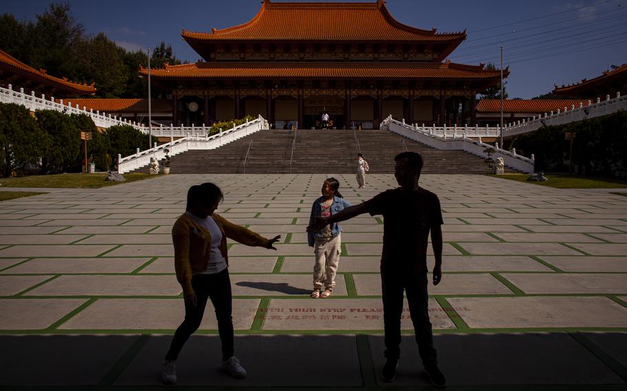 Lei Muhan and her parents visit Xilai Temple near their home in Los Angeles in May. The family arrived in the United States in April, joining the largest wave of illegal border crossings by Chinese migrants in history. The family’s motivation for coming to the United States was both economic and political.