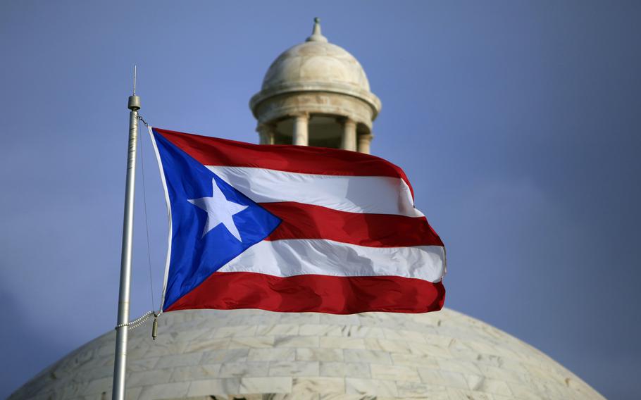 A flag flies in front of a building.