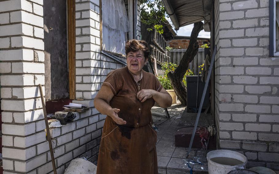 Tokareva’s childhood friend Tetiana Skrynnikova, her dress stained by blood from her own injuries, cries outside her home after Tokareva’s death.