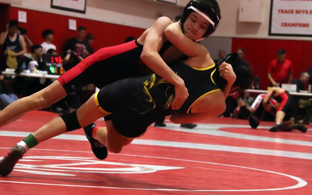 Kinnick's Ian Flynn sends ASIJ's Natalie Bonsi to the mat at 107 pounds.