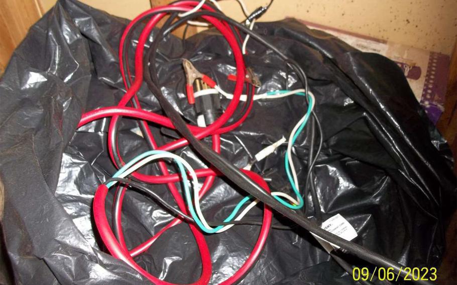 A black plastic bag full of jumper cables.