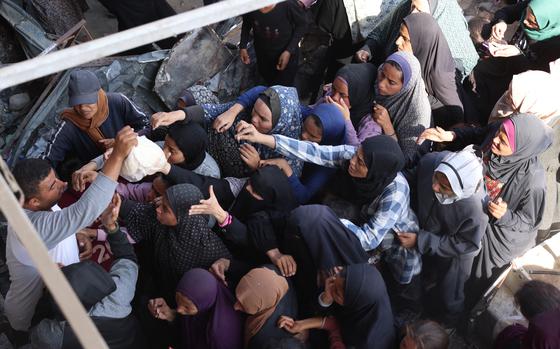 Palestinians wait in a line to receive bread outside a bakery in Khan Yunis on the southern Gaza Strip on Oct. 29, 2024, amid the ongoing war between Israel and the Palestinian militant group Hamas. (Bashar Taleb/AFP/Getty Images/TNS)