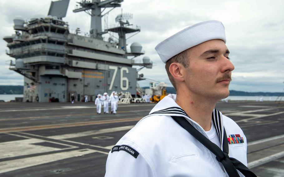 A Petty Officer 3rd Class Nathan Dunfee, of Shadyside, Ohio, mans the USS Ronald Reagan's rails as the aircraft carrier approaches Naval Base Kitsap in Bremerton, Wash., Aug. 13, 2024.  