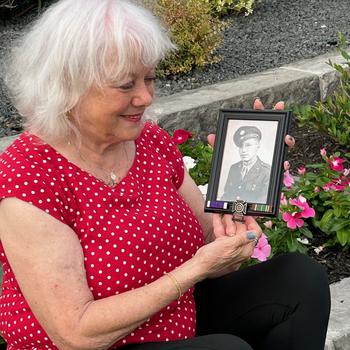 Susan Trammell holds a photo of her father, Army Pfc. DeVerl Stevens, outside her Texas home on May 24, 2024. Her father died in Germany shortly before she was born.