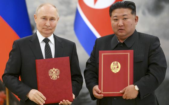 Russian President Vladimir Putin, left, and North Korea's leader Kim Jong Un pose for a photo during a signing ceremony of the new partnership in Pyongyang, North Korea, on June 19, 2024.