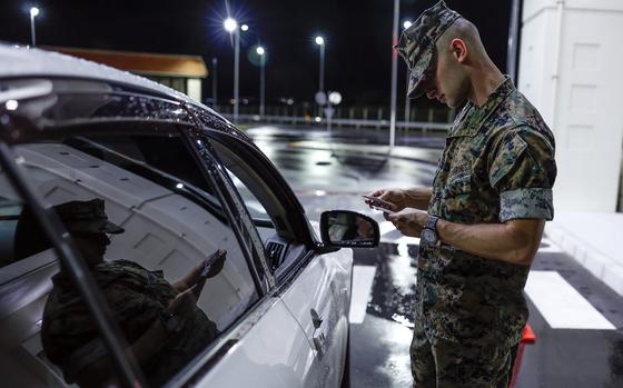 First Lt. Aivree Kamalzadeh of the 31st Marine Expeditionary Unit verifies liberty cards and driving documents on Camp Hansen, Okinawa, July 19, 2024.