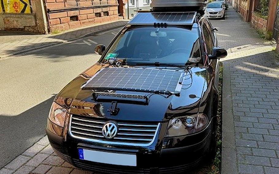 A modified VW Passat sits parked on Parkstraße in Kaiserslautern, Germany, on Tuesday, Aug. 27, 2024. The vehicle, equipped with homemade additions including solar panels, LED lights, and a trash bag hanging from a hook, was deemed unsafe by Westpfalz Police, who revoked its operating license.