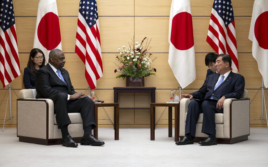 Secretary of Defense Lloyd Austin sits across from Japanese Prime Minister Shigeru Ishiba.