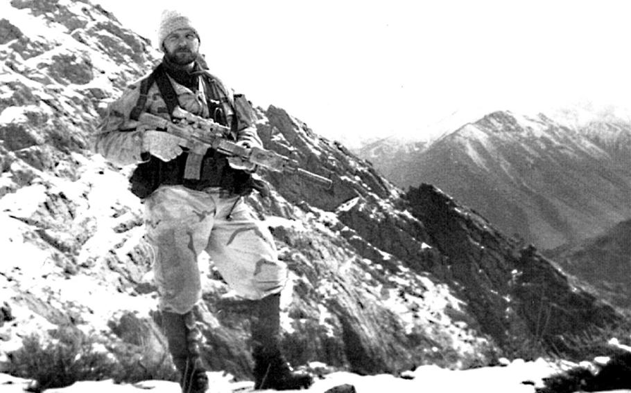 Master Sgt. John  Chapman stands in front of mountains in Afghanistan.