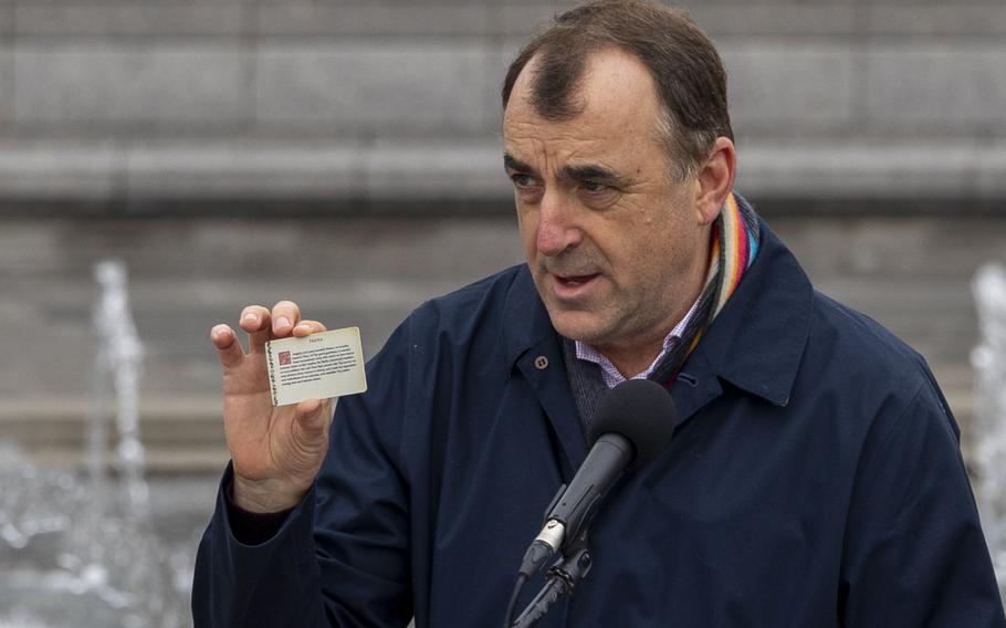 Historian holds up a card at the ceremony.