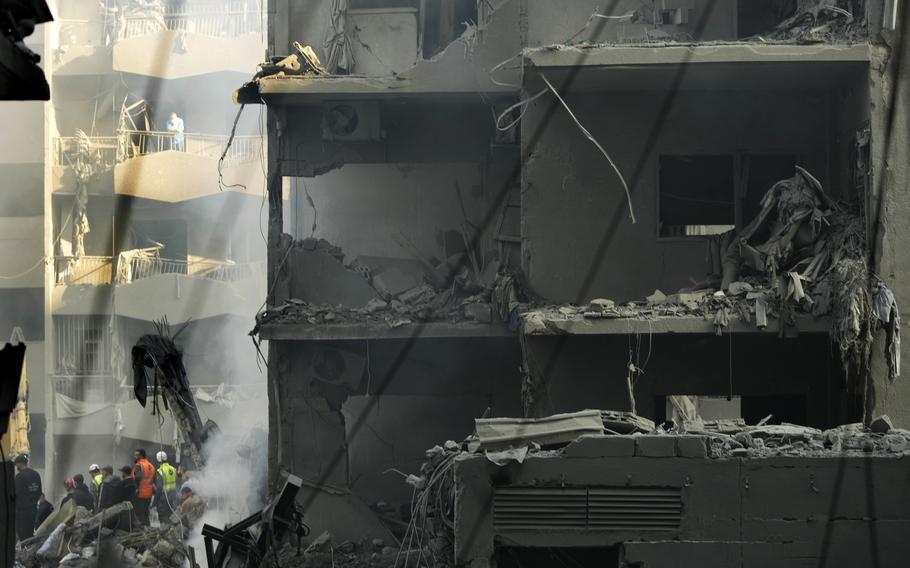 Rescue workers and people gather at the site of an Israeli airstrike that hit central Beirut, Lebanon, Saturday, Nov. 23, 2024. 