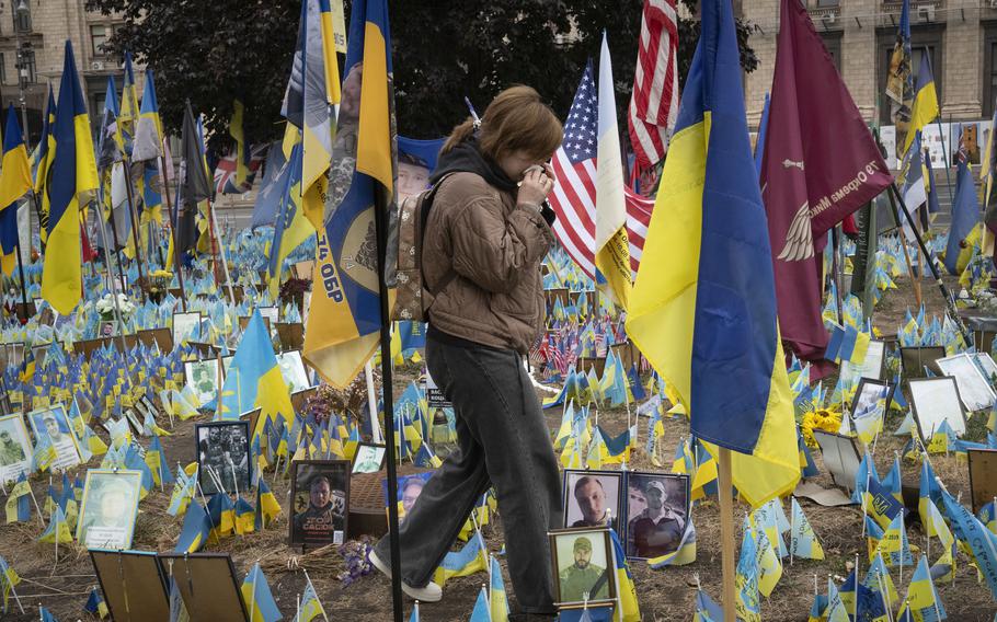 Ukrainians react during a nationwide minute of silence in memory of fallen soldiers