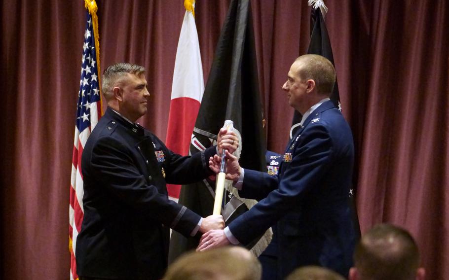 Brig. Gen. Anthony Mastalir, left, head of U.S. Space Forces Indo-Pacific, hands the U.S. Space Forces Japan guidon to Col. Ryan Laughton.