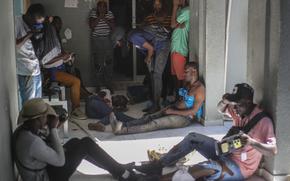 Journalists sit wounded after being shot by armed gangs at the General Hospital in Port-au-Prince, Haiti, Tuesday, Dec. 24, 2024. (AP Photo/Jean Feguens Regala)