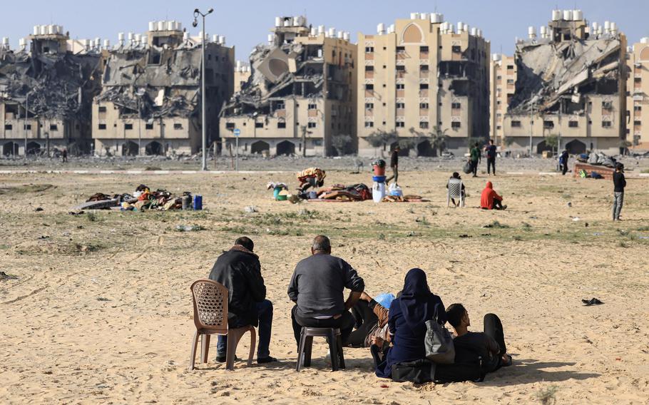 Residents of the Qatari-funded Hamad Town residential complex in Khan Yunis in the southern Gaza Strip sit with some of their belongings as they flee their homes after an Israeli strike on Saturday, Dec. 2, 2023.