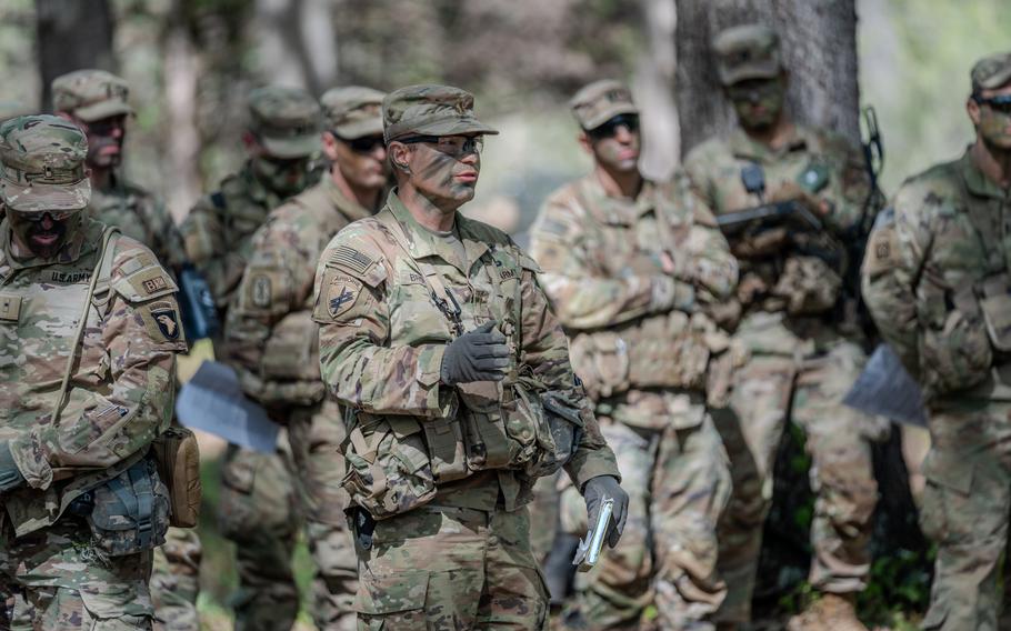 Several soldiers gathered in fatigues and gear for training exercise.