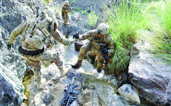 Khost province, Afghanistan, Aug. 17, 2013: Sgt. Joshua Sutherland, left, helps 2nd Lt. George Fletcher up a waterfall as Sgt. Damon Miers looks on. The members of Easy Company were assisting Afghan security forces in searching a remote village in Khost province.

Assigned to the 4th Combat Brigade Team, 101st Airborne Division, the men of 1st Platoon are members of Easy Company, 2nd Battalion, 506th Infantry Regiment, one of the most famed units in the U.S. Army thanks to the book, later made into an HBO miniseries, “Band of Brothers.” 
The sun-baked mountains of Afghanistan are far removed from the hedgerows of Normandy and the frozen forests of Belgium where Easy Company first made a name for itself during World War II, but the soldiers today are keen to live up to that heritage.

Read more at: https://www.stripes.com/migration/modern-band-of-brothers-unit-draws-on-historic-bonds-while-forging-their-own-1.migrated

META TAGS: Operation Enduring Freedom, Afghanistan; Band of Brothers; Easy Company; Wars on Terror; U.S. Army