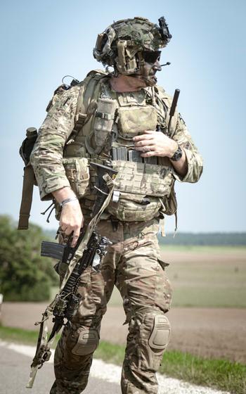 A soldier with the 173rd Airborne Brigade links up with his team after parachuting into a field outside of the Joint Multinational Readiness Center Hohenfels Training Area for Exercise Saber Junction on Sept. 4, 2024.