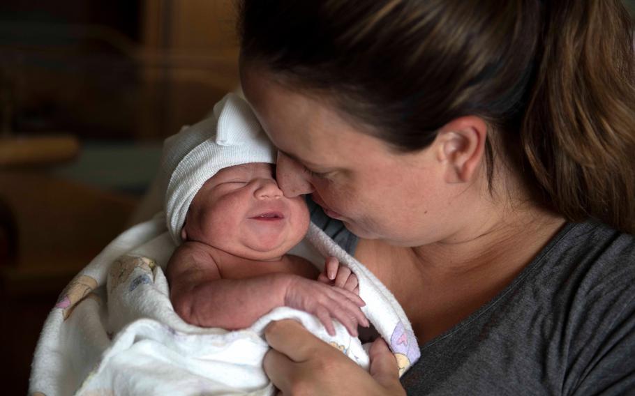 A mother and her newborn daughter snuggle following an evaluation of the infant at the U.S. Naval Hospital in Okinawa, Japan, in 2023. The Defense Department will now cover the costs of shipping breast milk during PCS moves, according to new policy.