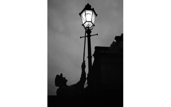 Munich, Germany, July 1961: Munich city lantern ward Wilhelm Schuepfer lights a gas street light.

Looking for Stars and Stripes’ historic coverage? Subscribe to Stars and Stripes’ historic newspaper archive! We have digitized our 1948-1999 European and Pacific editions, as well as several of our WWII editions and made them available online through https://starsandstripes.newspaperarchive.com/

Europe; West Germany; lamp; dusk; city; shadows; silhouette;