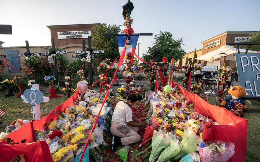 Cheryl Jackson arranges flowers at a makeshift memorial on Monday outside Allen Premium Outlets, where a gunman killed eight people and wounded seven before being killed by police on May 6, 2023, in Allen, Texas. 