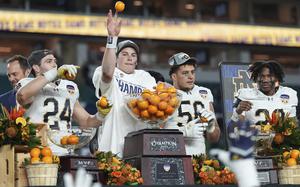 Notre Dame quarterback Riley Leonard throws oranges to his teammates after winning the Orange Bowl College Football Playoff semifinal game against Penn State, Thursday, Jan. 9, 2025, in Miami Gardens, Fla. (AP Photo/Rebecca Blackwell)