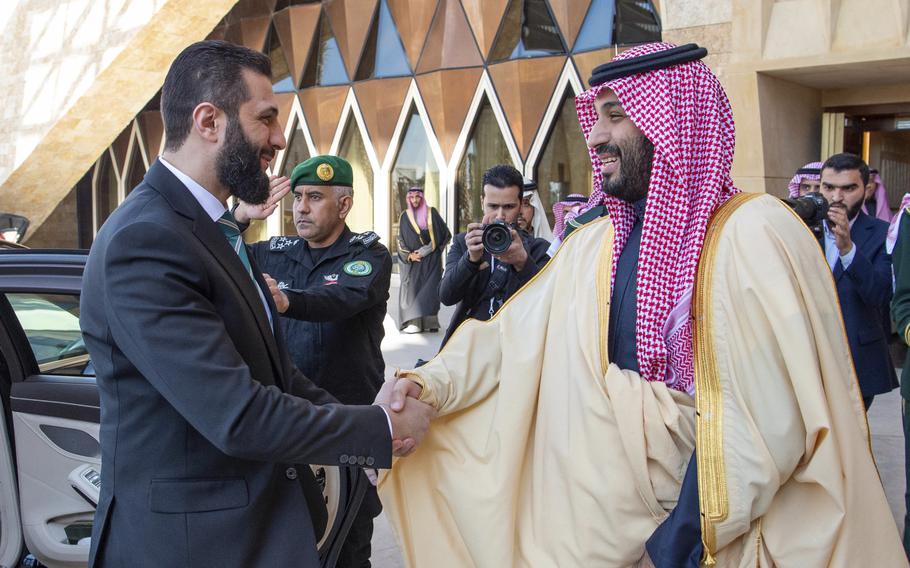 Ahmad al-Sharaa shakes hands with Mohammed bin Salman.