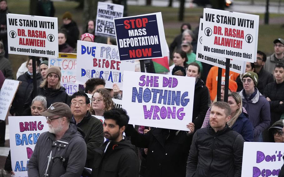 Protesters hold signs reading “She did nothing wrong” and “Stop mass deportation now,” among other things.