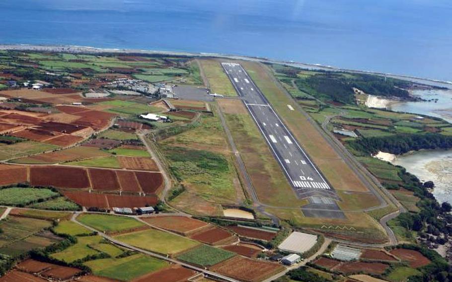 An aerial view of a runway in a rural area along a coastline.