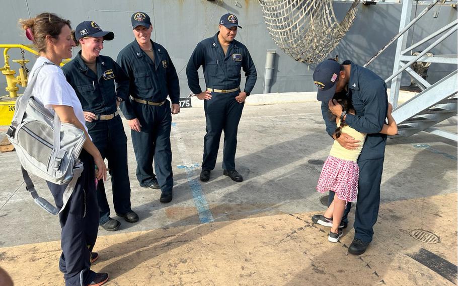 A 7-year-old girl hugs a sailor assigned to the USS William P. Lawrence at Joint Base Pearl Harbor-Hickam in Honolulu on Aug. 28, 2024, after crew members of the ship rescued the girl and her mother from rough seas about 900 miles east of Hawaii.