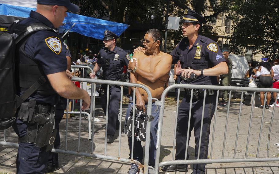 New York police officers escort a man injured during a shooting at the West Indian Parade, Monday, Sept. 2, 2024, in the Brooklyn borough of New York.