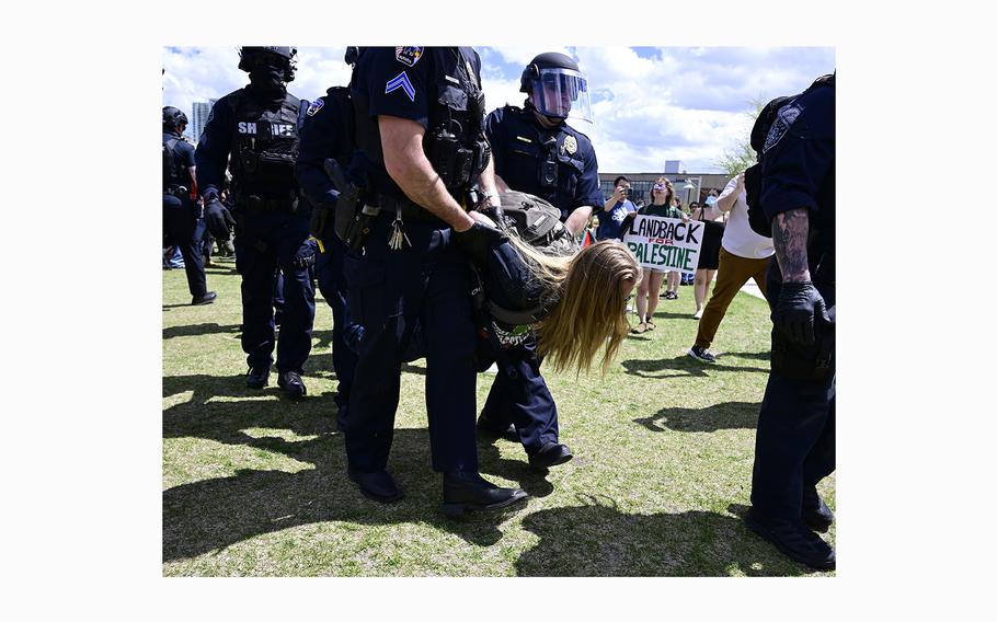 Police take a pro-Palestine protester to a Denver sheriff’s bus to be processed as law enforcement officers cleared a protest encampment on the Auraria Campus on April 26, 2024.