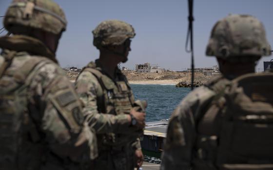 U.S. Army soldiers stand at the floating pier Trident off the coast of the Gaza Strip on June 25, 2024.