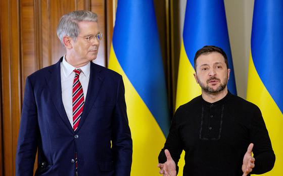 The U.S. Treasury Secretary next to the president of Ukraine, in front of Ukrainian flags.