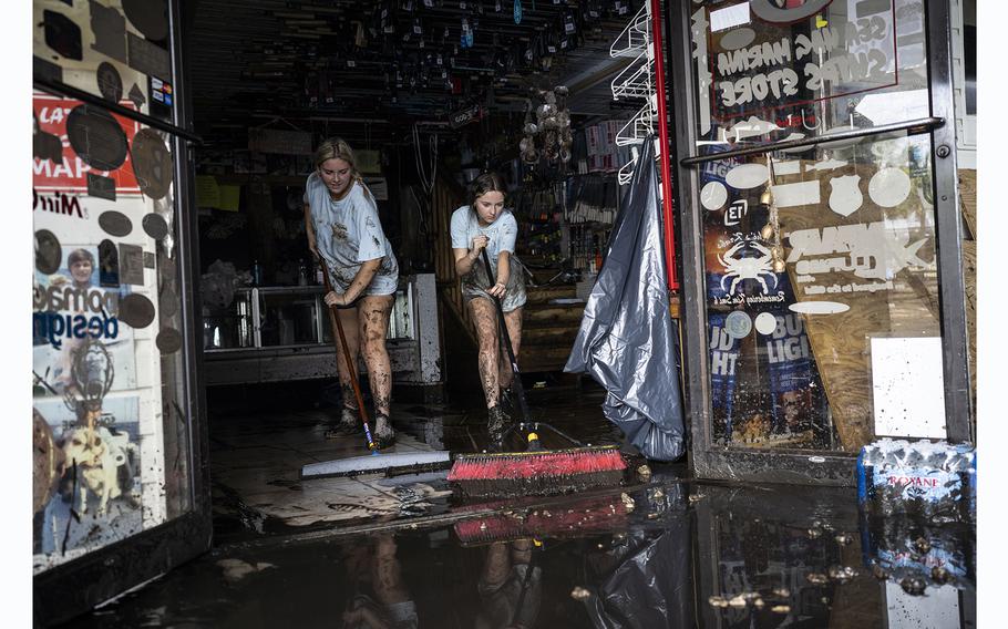 Katie Cole, left, and her sister, Savannah Cole, clean mud out of the Sea Hag Marina gift shop, where they work as cashiers, on Thursday, Aug. 31, 2023, in Steinhatchee, Florida.