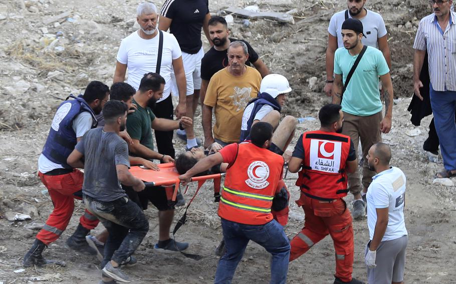 Rescuers carry an injured man on a strecher.