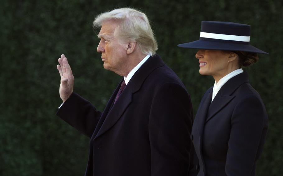 President-elect Donald Trump waves as he walks with his wife Melania