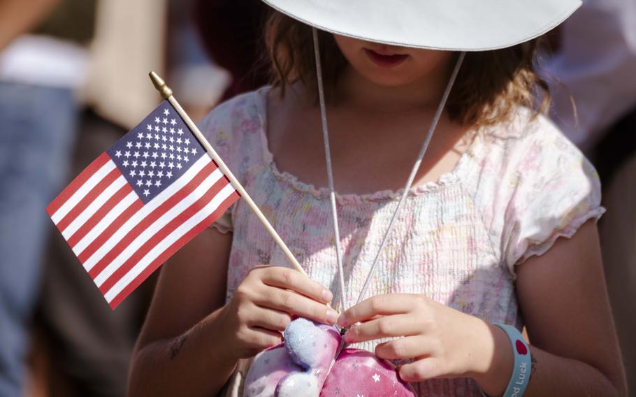 A Czech resident holds an American flag at the mass grave site of 28 fallen American World War II airmen during the 80th commemoration of the Battle over the White Carpathians at Slavicin, Czech Republic, on Aug. 31, 2024.