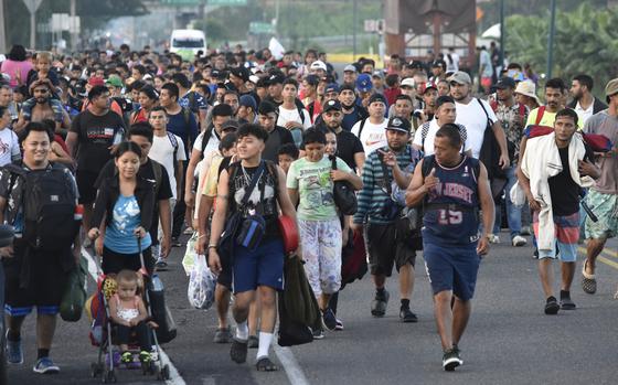 Migrants walk along the highway through Suchiate, Chiapas state in southern Mexico, Sunday, July 21, 2024, during their journey north toward the U.S. border. 