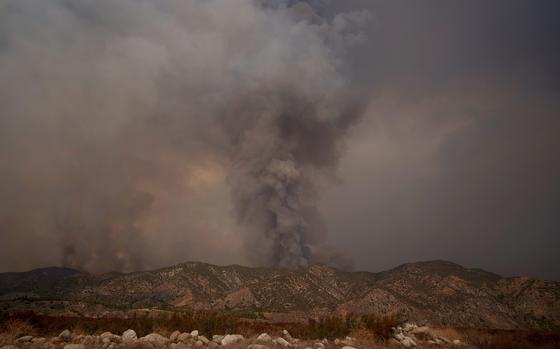 Smoke from the advancing Line Fire rises above a ridge in Mentone in San Bernardino County, Calif., Sunday, Sept. 8, 2024. (AP Photo/Eric Thayer)